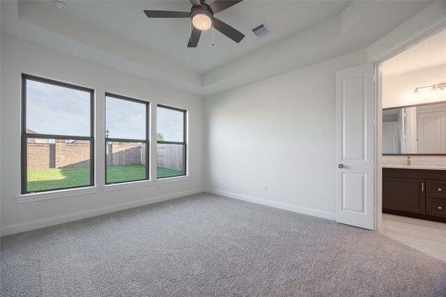 12810 Belford Gardens Dr, Humble, TX 77346 - empty room with ceiling fan, baseboards, light carpet, and a raised ceiling