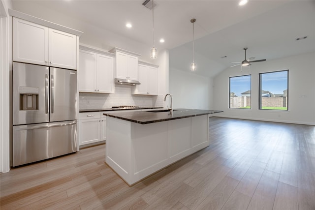 12810 Belford Gardens Dr, Humble, TX 77346 - kitchen with appliances with stainless steel finishes, a sink, decorative backsplash, lofted ceiling, and light wood-type flooring