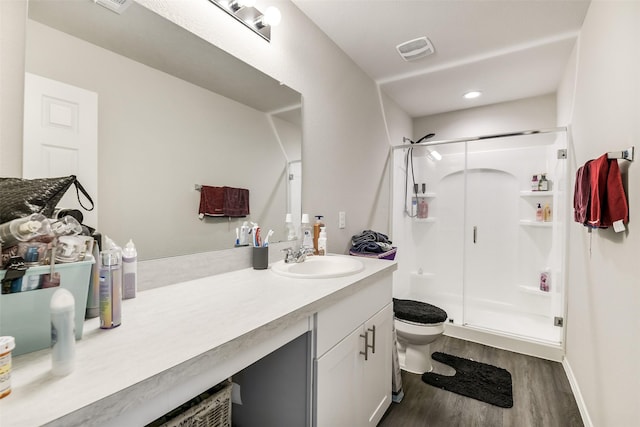 full bath with toilet, visible vents, wood finished floors, and a stall shower