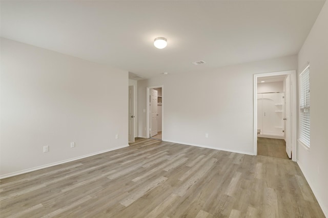 254 Cumberland Forest Dr, Magnolia, TX 77354 - unfurnished bedroom with light wood finished floors, baseboards, ensuite bath, and a walk in closet