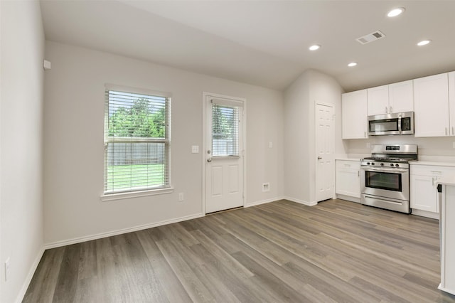 254 Cumberland Forest Dr, Magnolia, TX 77354 - kitchen featuring appliances with stainless steel finishes, light wood-style flooring, white cabinetry, light countertops, and recessed lighting