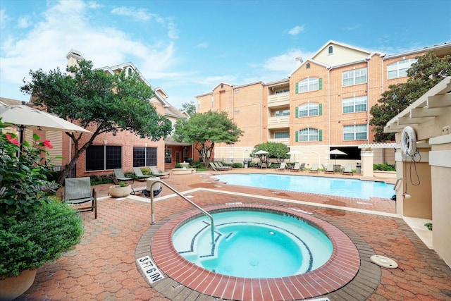 community pool with a hot tub and a patio area