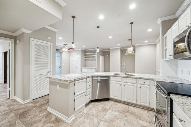 kitchen with white cabinets, appliances with stainless steel finishes, a sink, a ceiling fan, and a peninsula