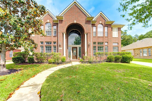 view of front of property with brick siding and a front lawn