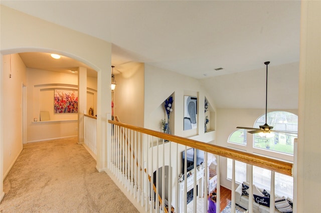 hallway featuring carpet floors and arched walkways