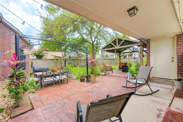 view of patio featuring a gazebo, a fenced backyard, an outdoor living space, and outdoor dining space