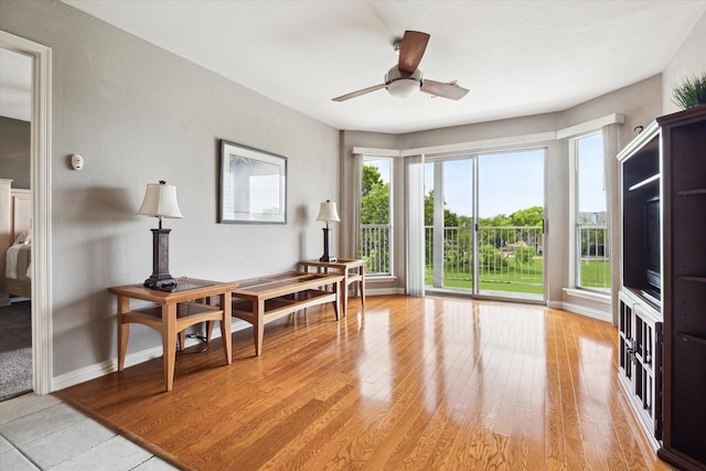 office featuring a ceiling fan, baseboards, and light wood-style floors