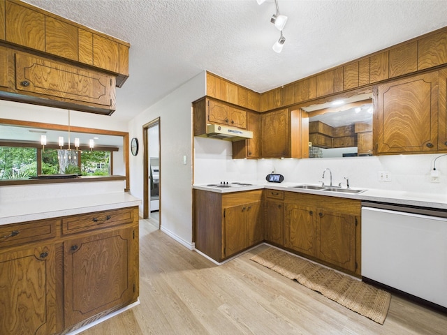 kitchen with white appliances, brown cabinets, a sink, and light wood-style floors