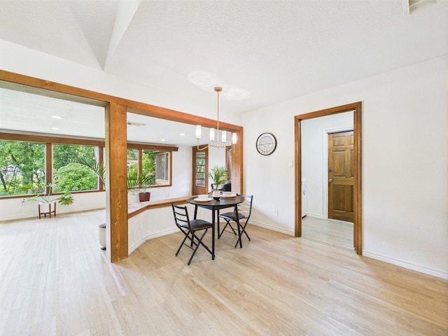 dining room with light wood-style floors, baseboards, an inviting chandelier, and visible vents