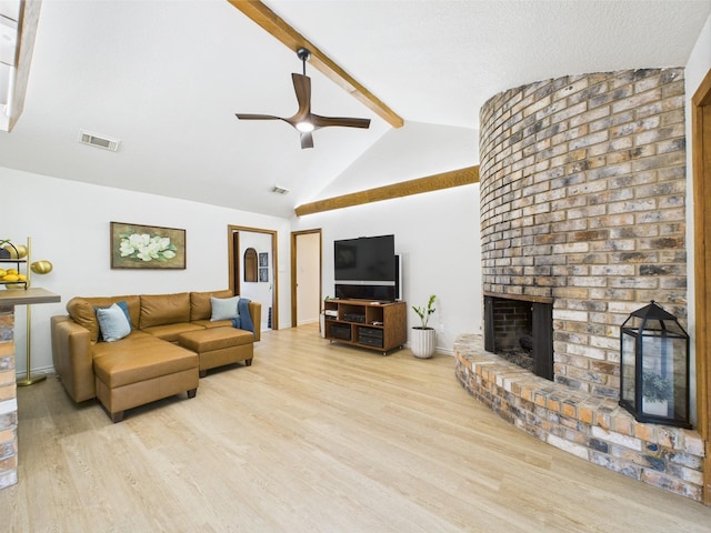 living area featuring a brick fireplace, ceiling fan, visible vents, and wood finished floors