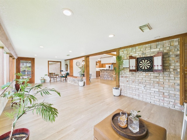 living room with a textured ceiling, recessed lighting, wood finished floors, and visible vents