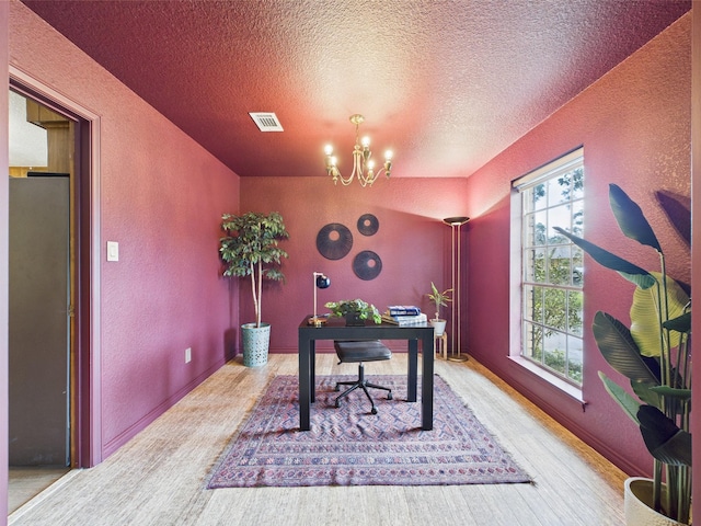 office space featuring a textured wall, an inviting chandelier, a textured ceiling, wood finished floors, and visible vents