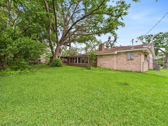 view of yard featuring central AC and fence