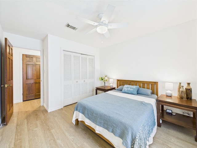 bedroom featuring light wood-style floors, a ceiling fan, baseboards, visible vents, and a closet