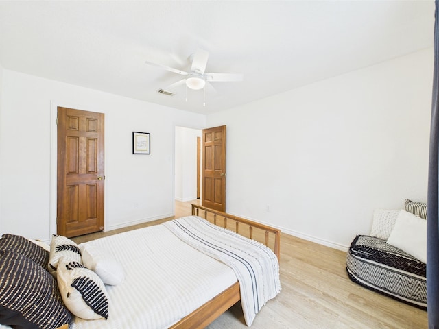bedroom with ceiling fan, baseboards, visible vents, and light wood-style flooring