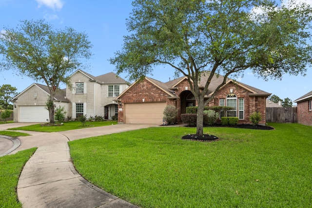 view of front of property with fence, an attached garage, brick siding, a front yard, and driveway
