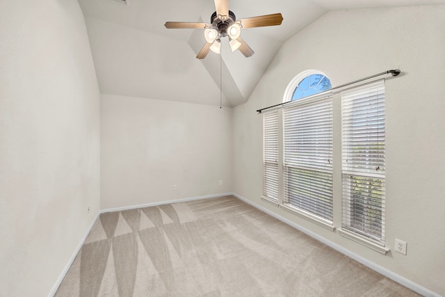 carpeted spare room featuring a ceiling fan, baseboards, and vaulted ceiling