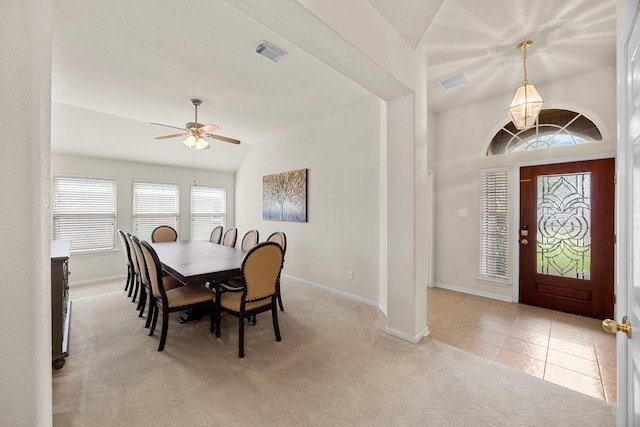dining space featuring ceiling fan, visible vents, vaulted ceiling, baseboards, and carpet flooring