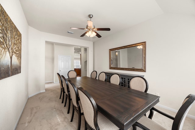 dining room with baseboards, ceiling fan, light carpet, and visible vents