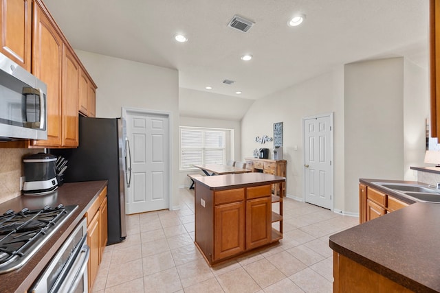 kitchen with visible vents, vaulted ceiling, dark countertops, and stainless steel appliances