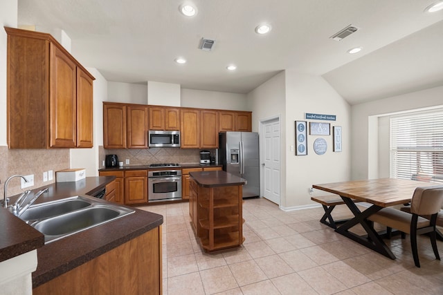 kitchen with visible vents, appliances with stainless steel finishes, tasteful backsplash, dark countertops, and a sink