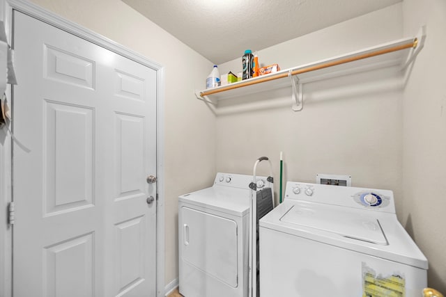 laundry area with a textured ceiling, laundry area, and washing machine and dryer