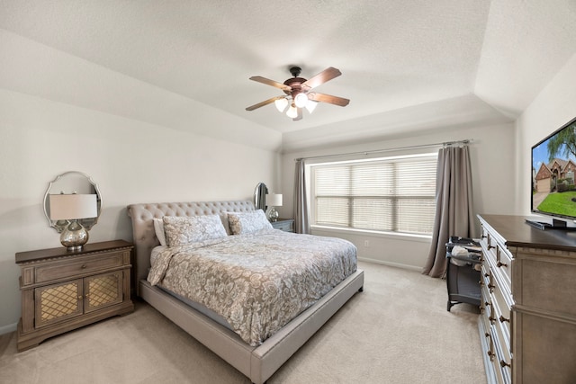 bedroom featuring ceiling fan, a textured ceiling, light colored carpet, vaulted ceiling, and baseboards