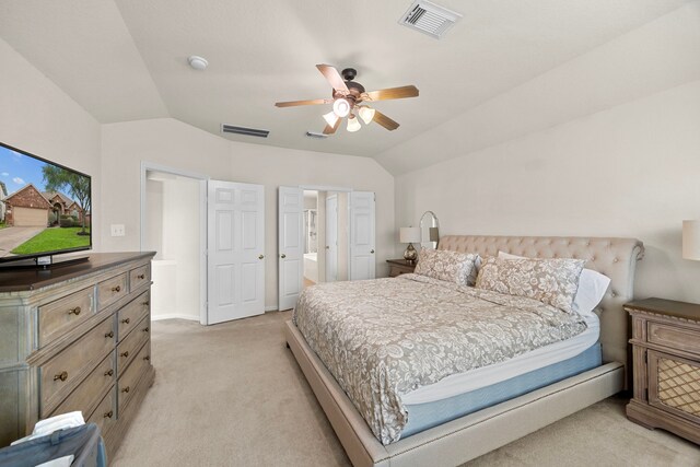 bedroom with visible vents, ceiling fan, vaulted ceiling, and light colored carpet