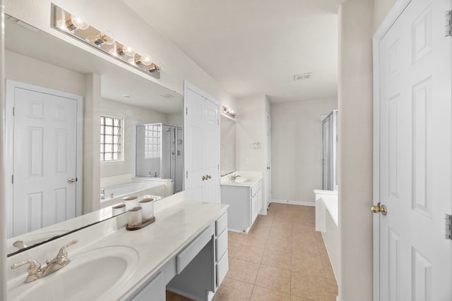 bathroom with a garden tub, a sink, tile patterned floors, and a stall shower