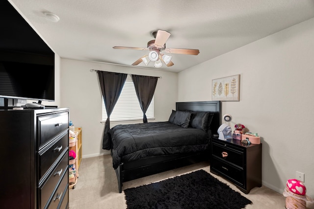 bedroom featuring baseboards, light colored carpet, and ceiling fan