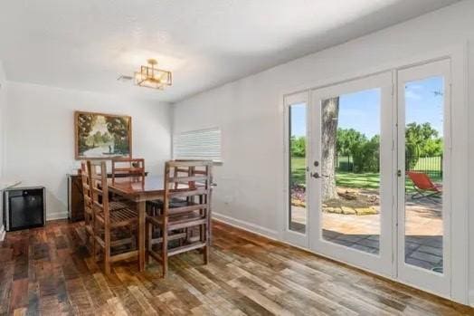 dining room featuring baseboards, a notable chandelier, and wood finished floors