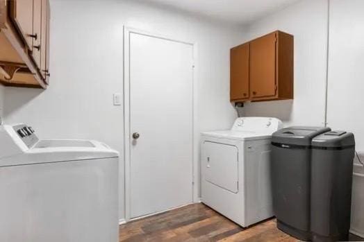 laundry area with separate washer and dryer, cabinet space, and light wood finished floors