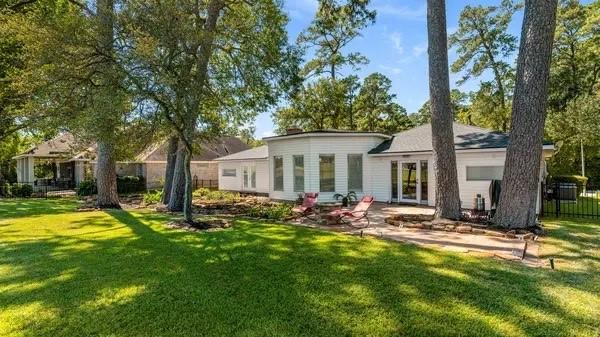 back of property with a lawn, fence, and a patio