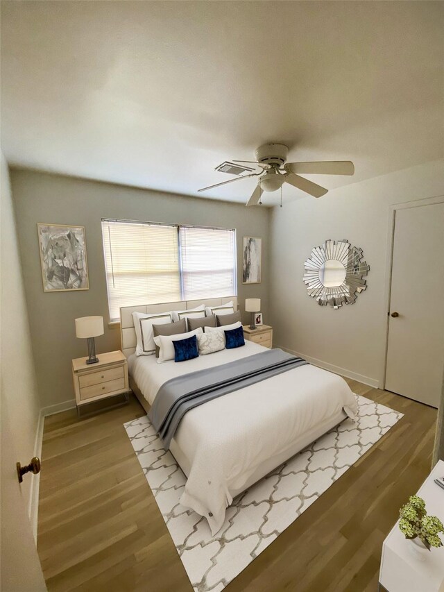 bedroom featuring baseboards, ceiling fan, and wood finished floors