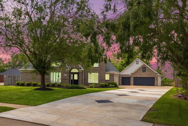 view of front of house with fence, brick siding, concrete driveway, an attached garage, and a yard