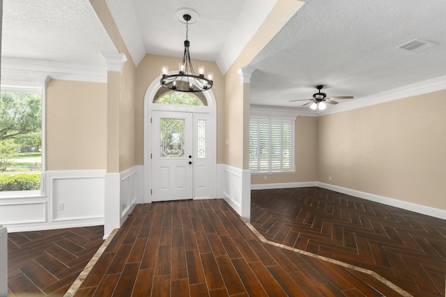 foyer entrance with a wainscoted wall, plenty of natural light, ceiling fan with notable chandelier, and visible vents