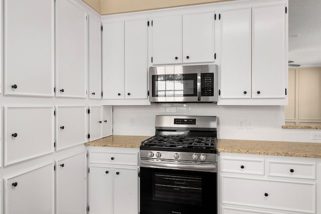 kitchen with tasteful backsplash, white cabinets, and stainless steel appliances
