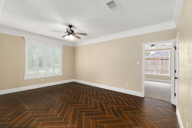 empty room featuring crown molding, baseboards, a ceiling fan, and visible vents