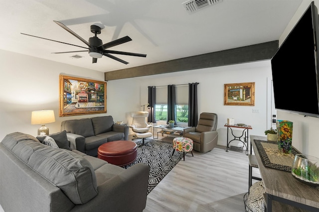 living room featuring visible vents, light wood-style floors, ceiling fan, and baseboards