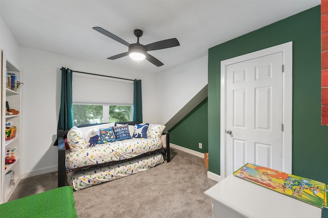 living area with baseboards, ceiling fan, and carpet flooring