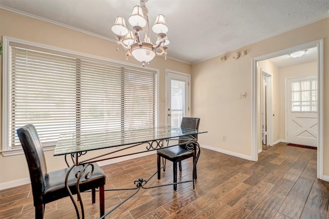 5611 Westerham Pl, Houston, TX 77069 - dining space with crown molding, baseboards, an inviting chandelier, and wood finished floors