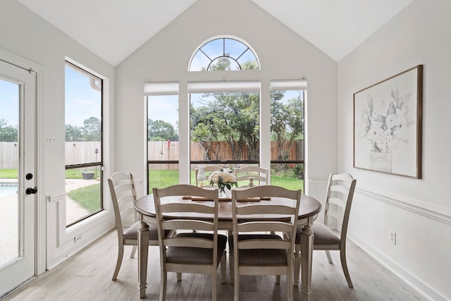 dining room with light wood finished floors and vaulted ceiling