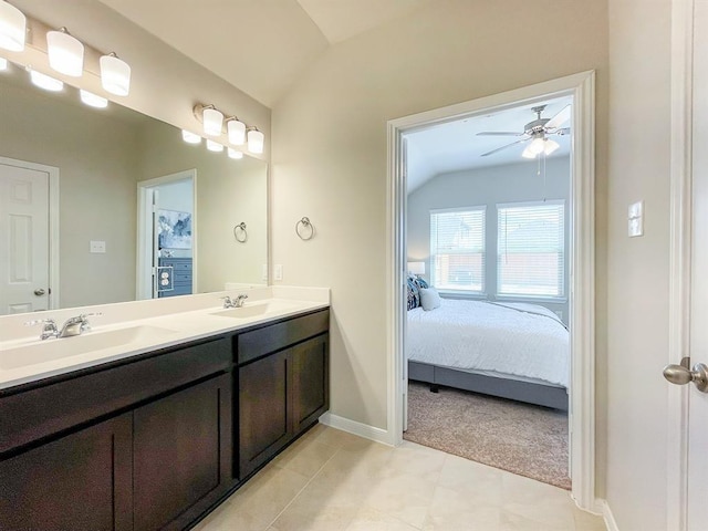 full bath with connected bathroom, ceiling fan, vaulted ceiling, and a sink