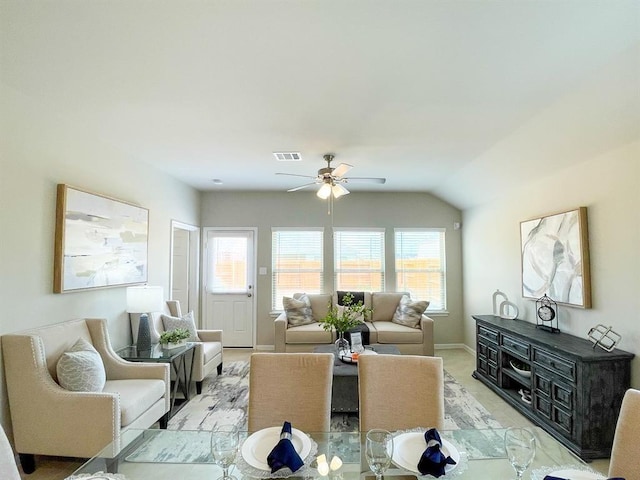living area featuring visible vents, a ceiling fan, baseboards, and a wealth of natural light
