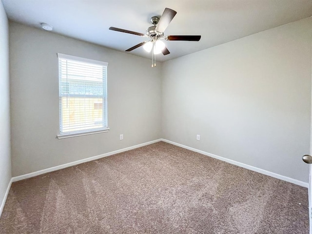 empty room featuring carpet floors, a ceiling fan, and baseboards