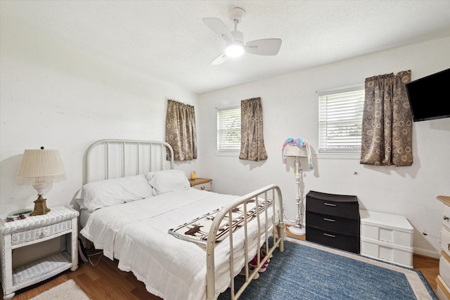 bedroom featuring a textured ceiling, ceiling fan, and wood finished floors