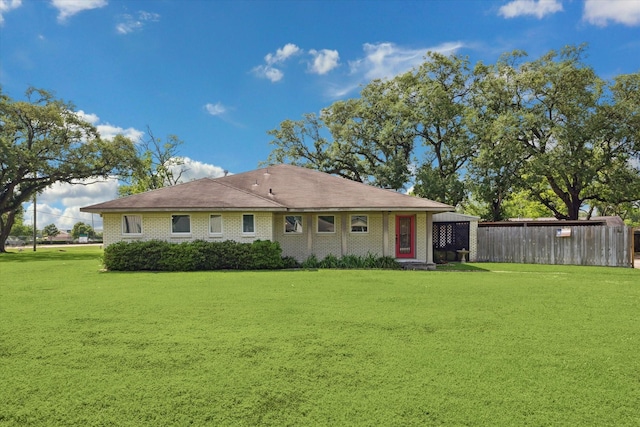 rear view of property with a lawn and fence