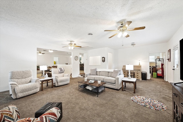 living room featuring a ceiling fan, a textured ceiling, and carpet