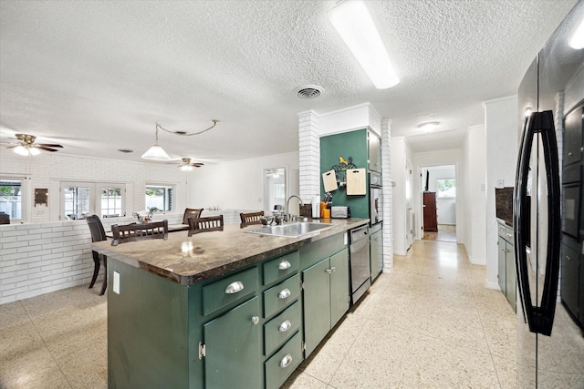 kitchen with a sink, green cabinetry, appliances with stainless steel finishes, and ceiling fan