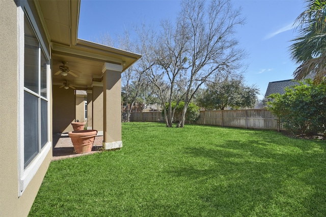 view of yard with a ceiling fan, a patio area, and a fenced backyard